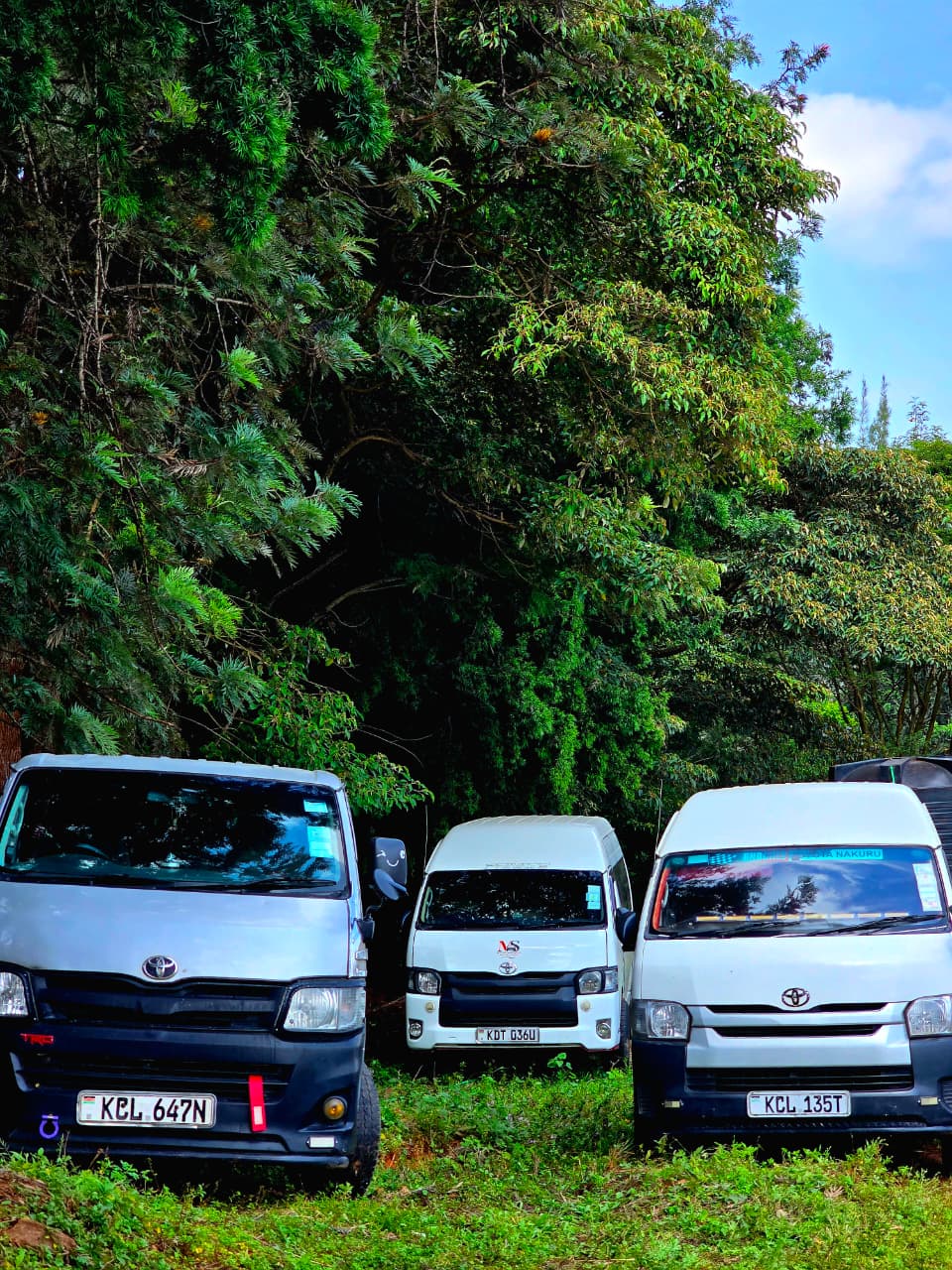 Three Mtemi Swift Rides vans parked together in the fleet yard